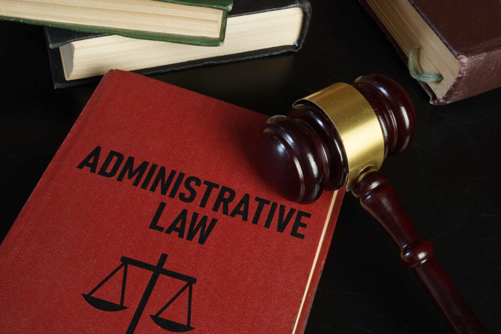 Administrative law book with judge’s gavel on desk representing legal and judicial concepts.