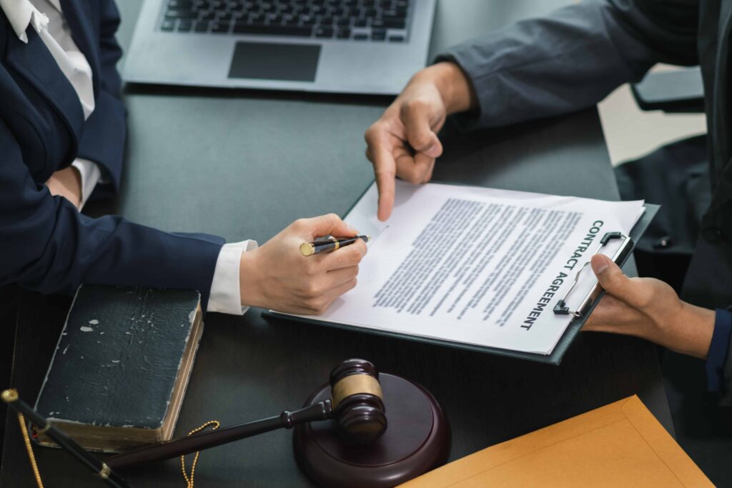 Lawyer reviewing and explaining contract agreement to client in legal office.